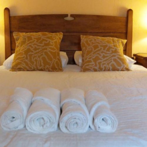 Dormitorio listo para huéspedes con toallas frescas en El Tinao de La Hiruela